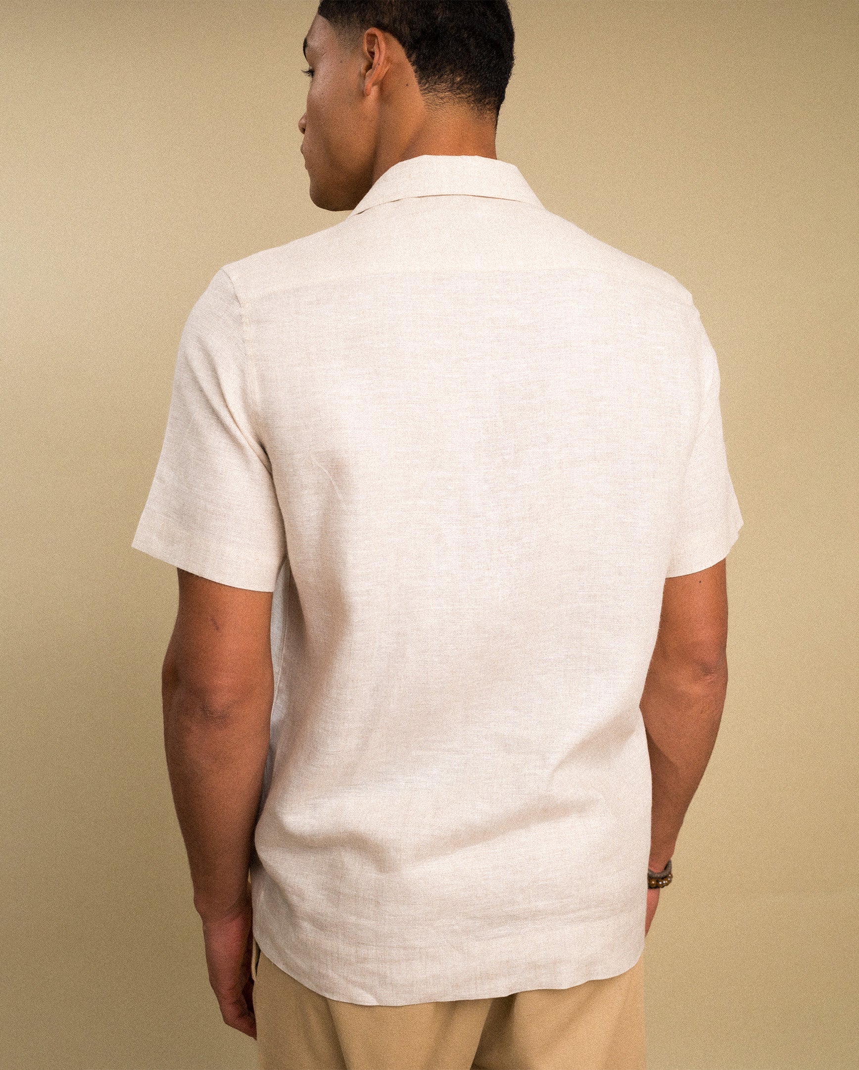 Beige guayabera linen shirt — back view showing straight hem and linen texture | Palma Camisería