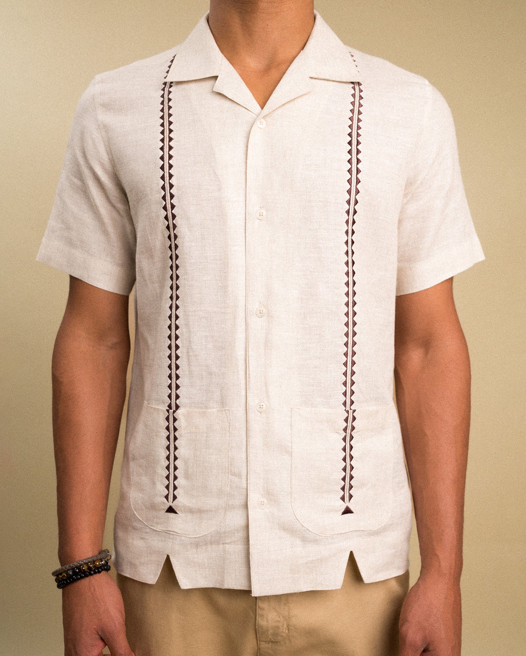 Beige guayabera shirt close-up — hand embroidery detail on 100% linen fabric | Palma Camisería