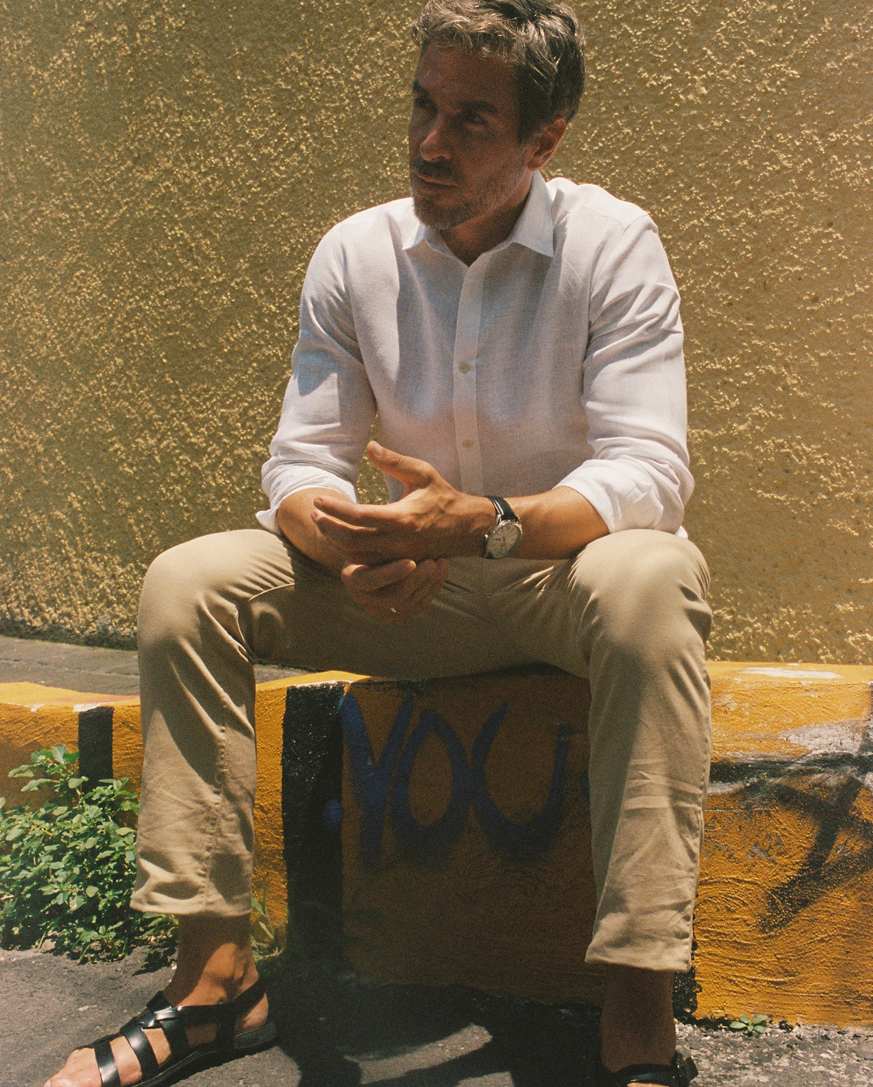 Khaki chino lifestyle — Encino men's chino pants worn sitting outdoors, Mexico street | Palma Camisería